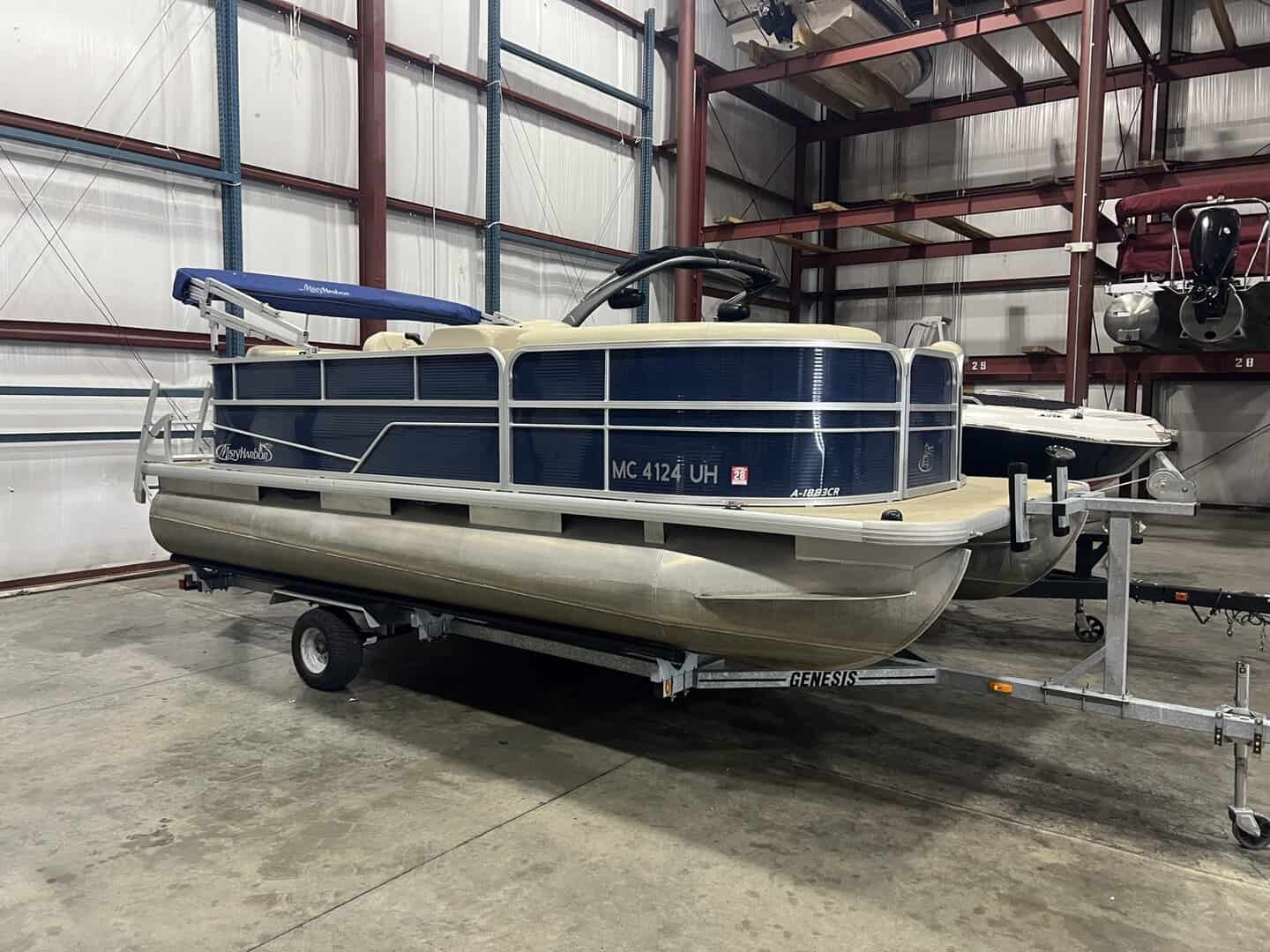 Pontoon boat stored indoors at Hall's Sport Center, ready for water adventures.
