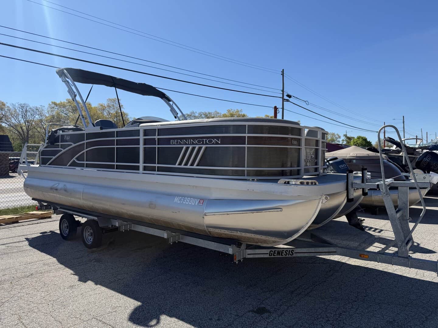 Bennington pontoon boat on trailer at Hall's Sport Center, ideal for boating and water recreation.