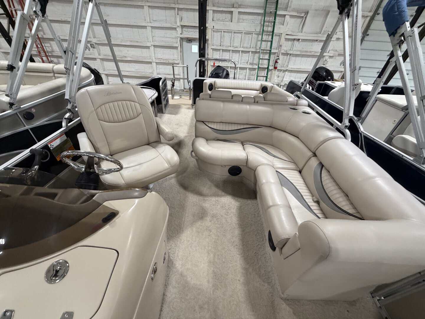 Luxury boat interior with beige seating and steering wheel at Hall's Sport Center.