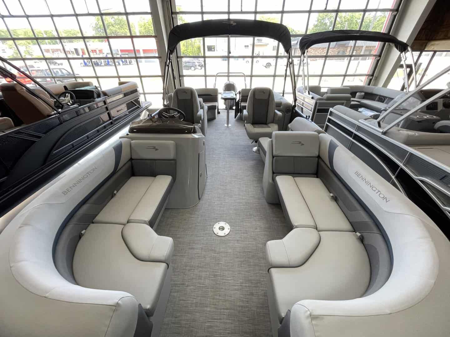 Luxury pontoon boat interior with seating and navigation controls at Hall's Sport Center.